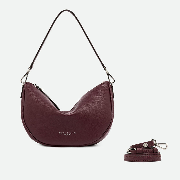 Burgundy leather half moon shoulder bag shown beside a separate long crossbody strap