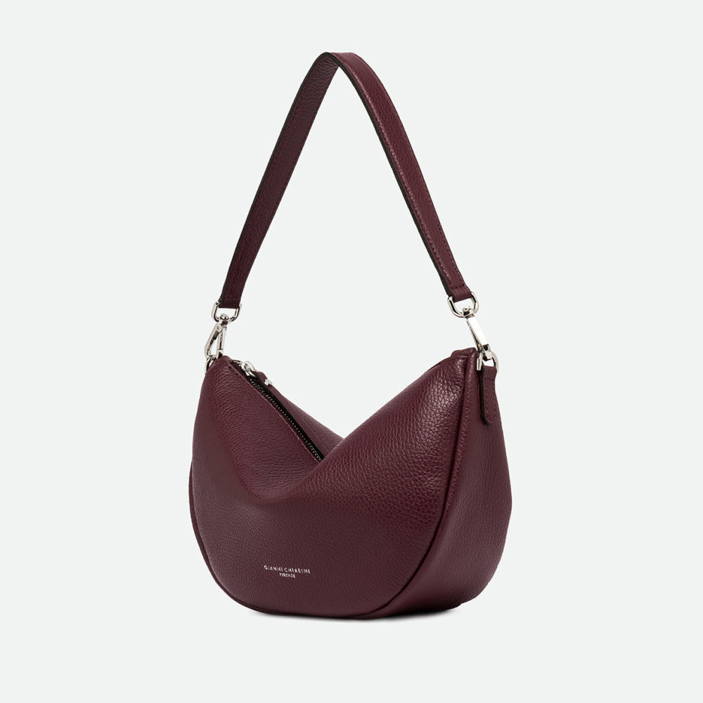 Side view of a burgundy leather half moon shoulder bag