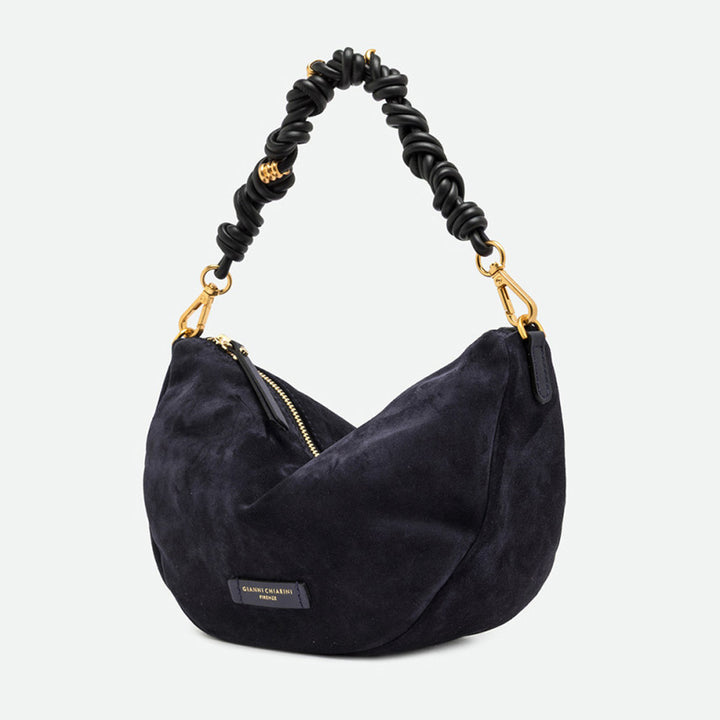 Side view of a navy suede half moon bag with gold clasps