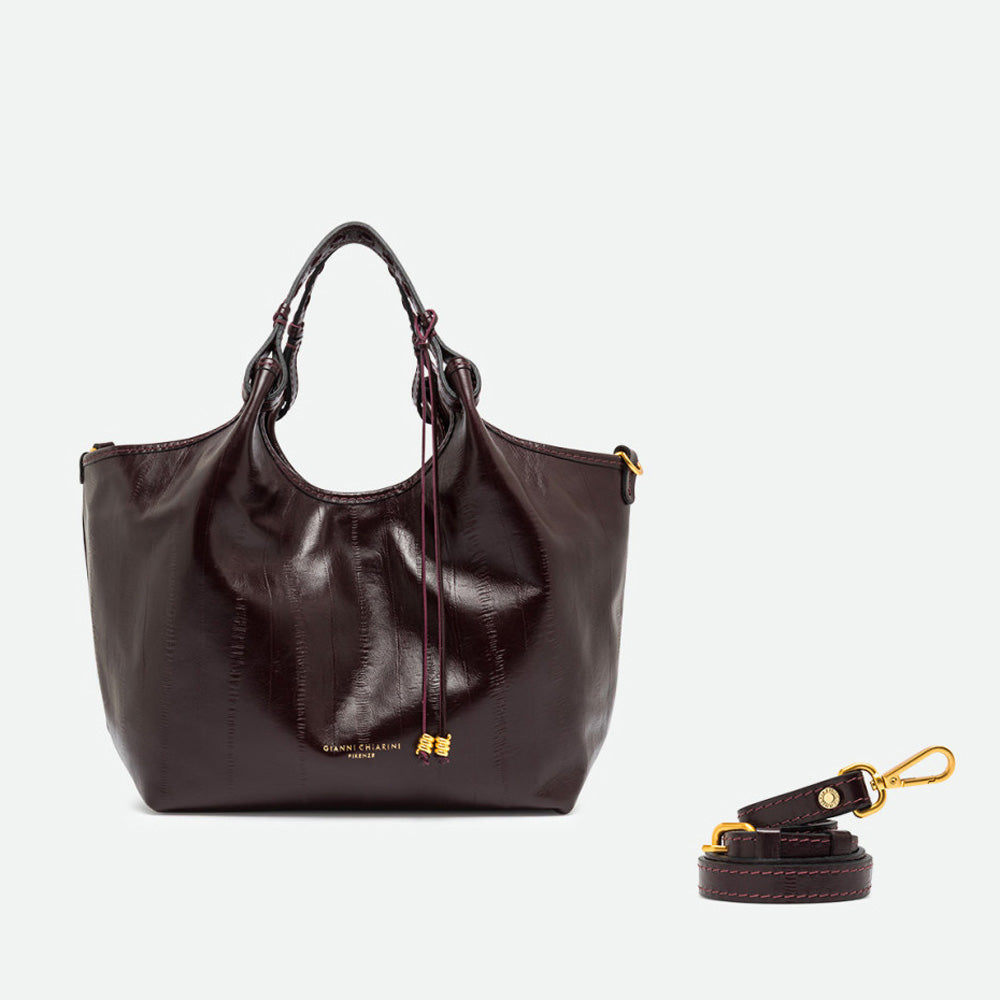 Dark burgundy leather tote with its sides opened out, beside a separate shoulder strap