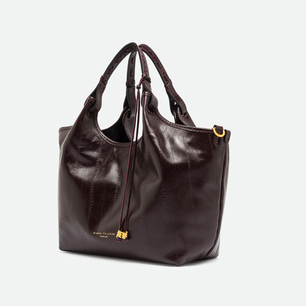 Angled view of a glossy dark burgundy leather tote bag