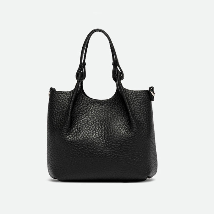 Front of a small black pebbled leather tote with its sides opened out