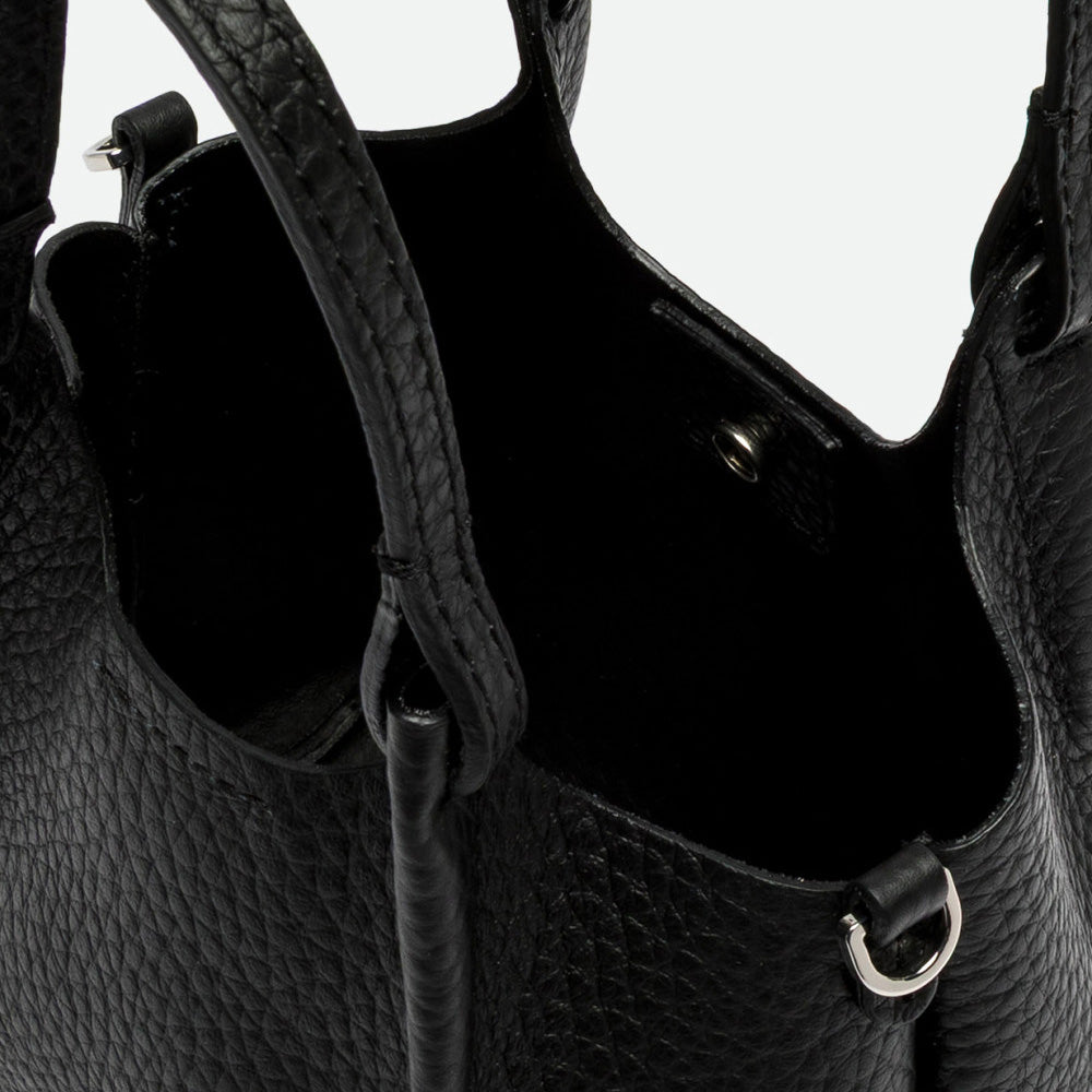 Inside a black leather bag showing the unlined interior and magnetic clasp