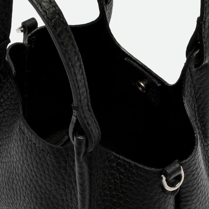 Inside a black leather bag showing the unlined interior and magnetic clasp