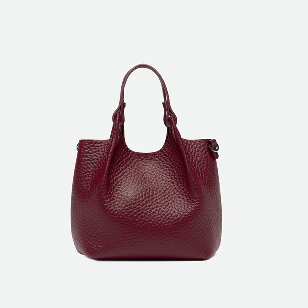 Front of a small deep red pebbled leather tote with its sides opened out