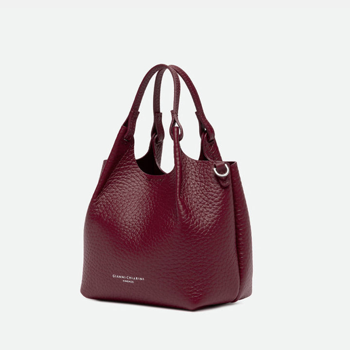 Angled view of a small deep red pebbled leather tote bag