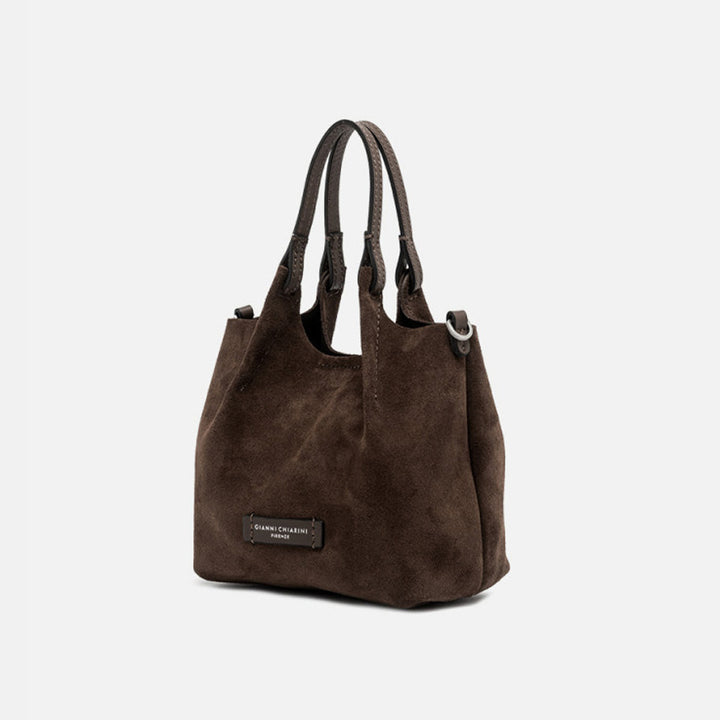 Angled view of a small dark brown suede tote bag