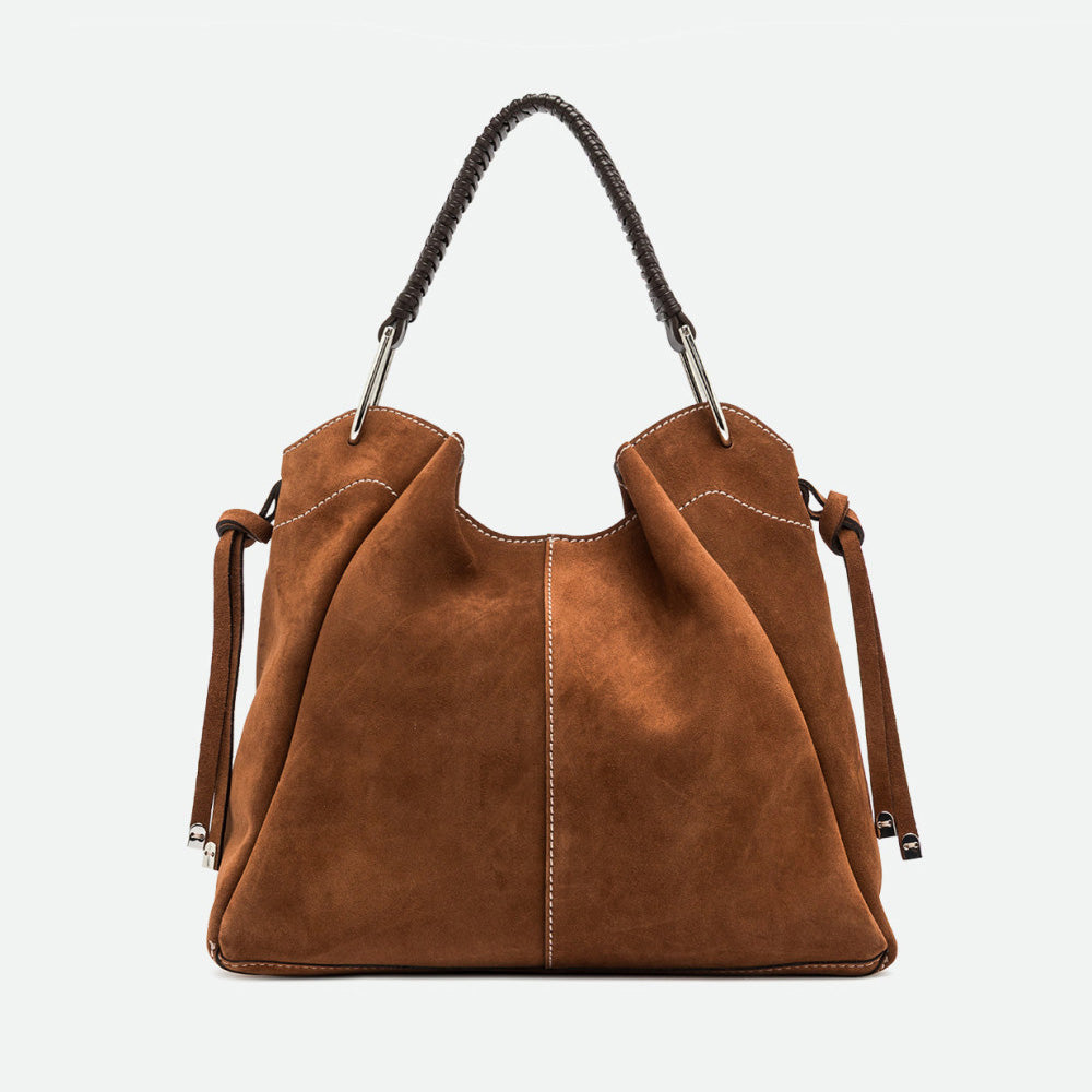 Front of a large tan suede shoulder bag with buckled side straps