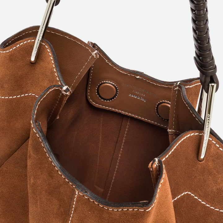 Inside a tan suede bag showing the brown interior and contrast stitching