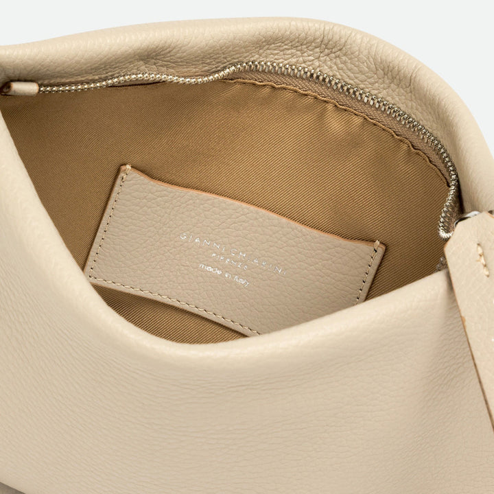Inside a cream leather bag showing a beige lining and cream leather label