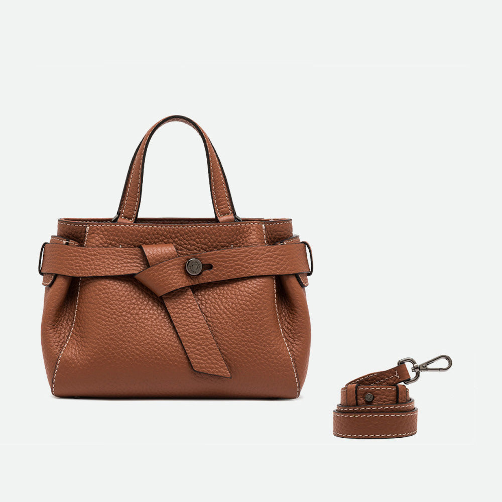 Tan leather top handle bag shown beside a separate long crossbody strap