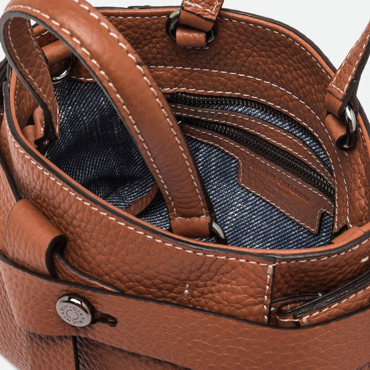 Inside a tan leather bag showing a blue denim-look lining and zip pocket
