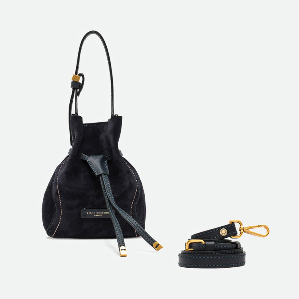 Small navy suede bucket bag shown beside a separate crossbody strap