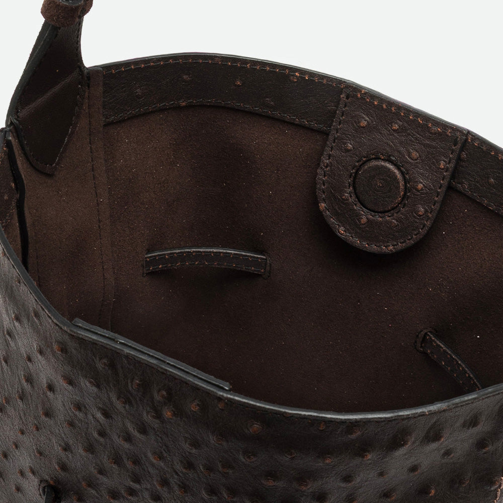 Inside a dark brown bucket bag showing the textured leather and suede interior