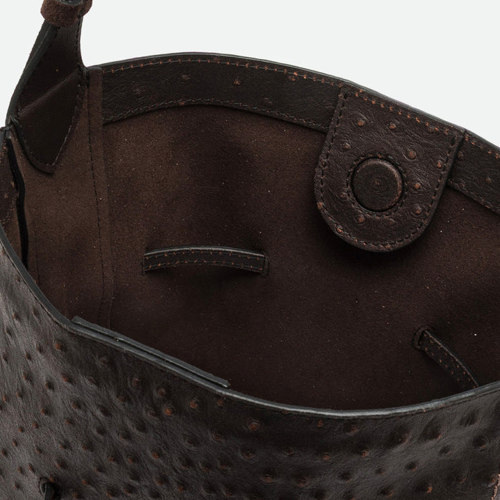 Inside a dark brown bucket bag showing the textured leather and suede interior