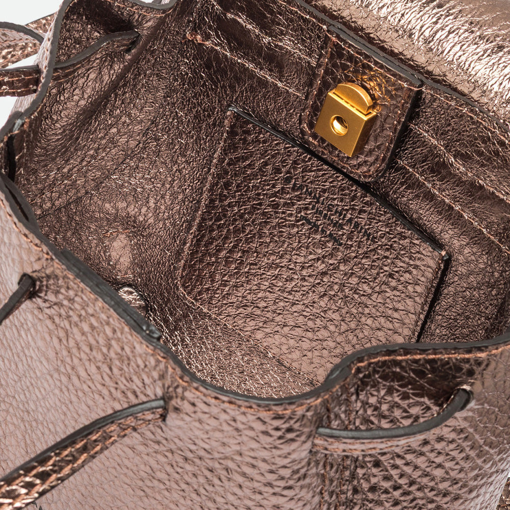 Inside a bronze metallic backpack showing a gold clasp and interior pocket