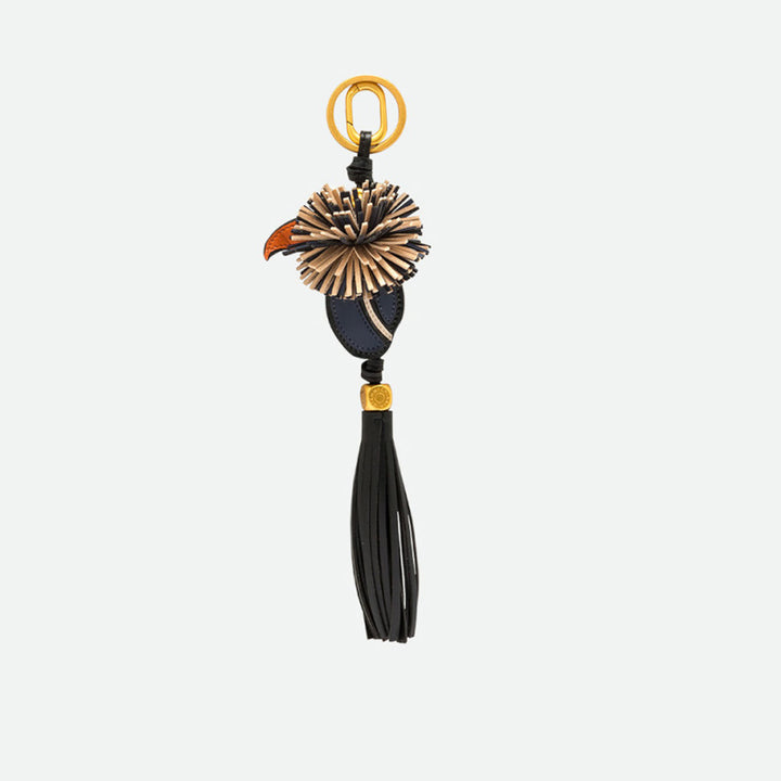 Reverse side of a toucan bag charm with a fringed crest and black tassel
