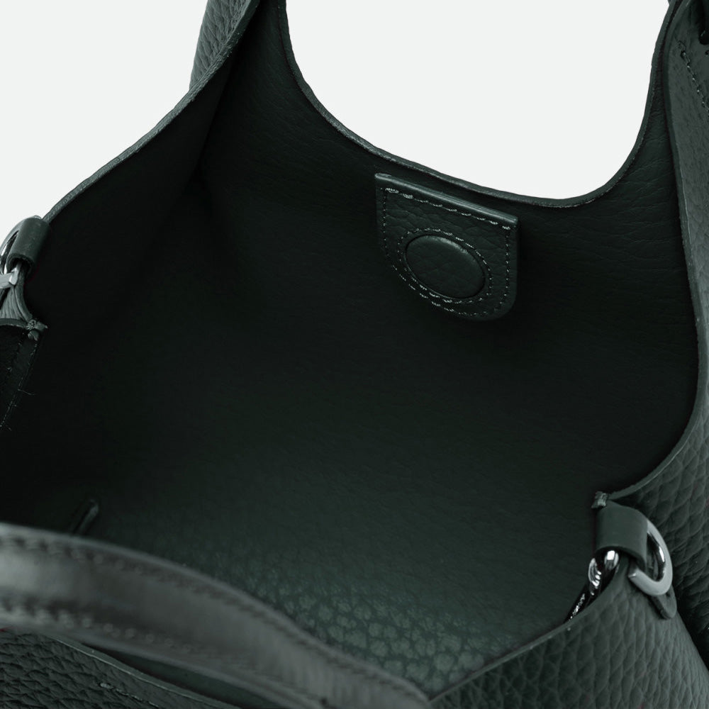 Inside a dark green leather tote showing the green interior and magnetic clasp
