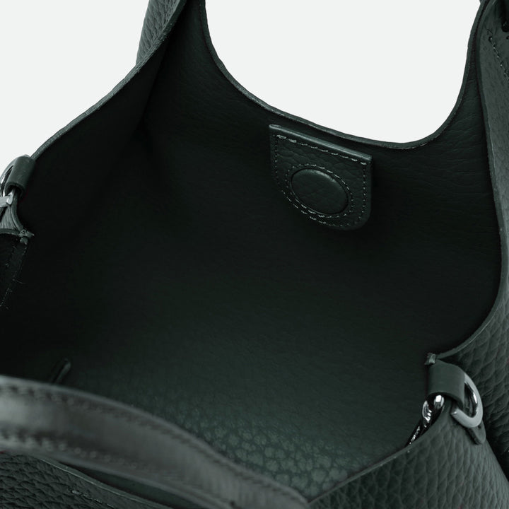 Inside a dark green leather tote showing the green interior and magnetic clasp