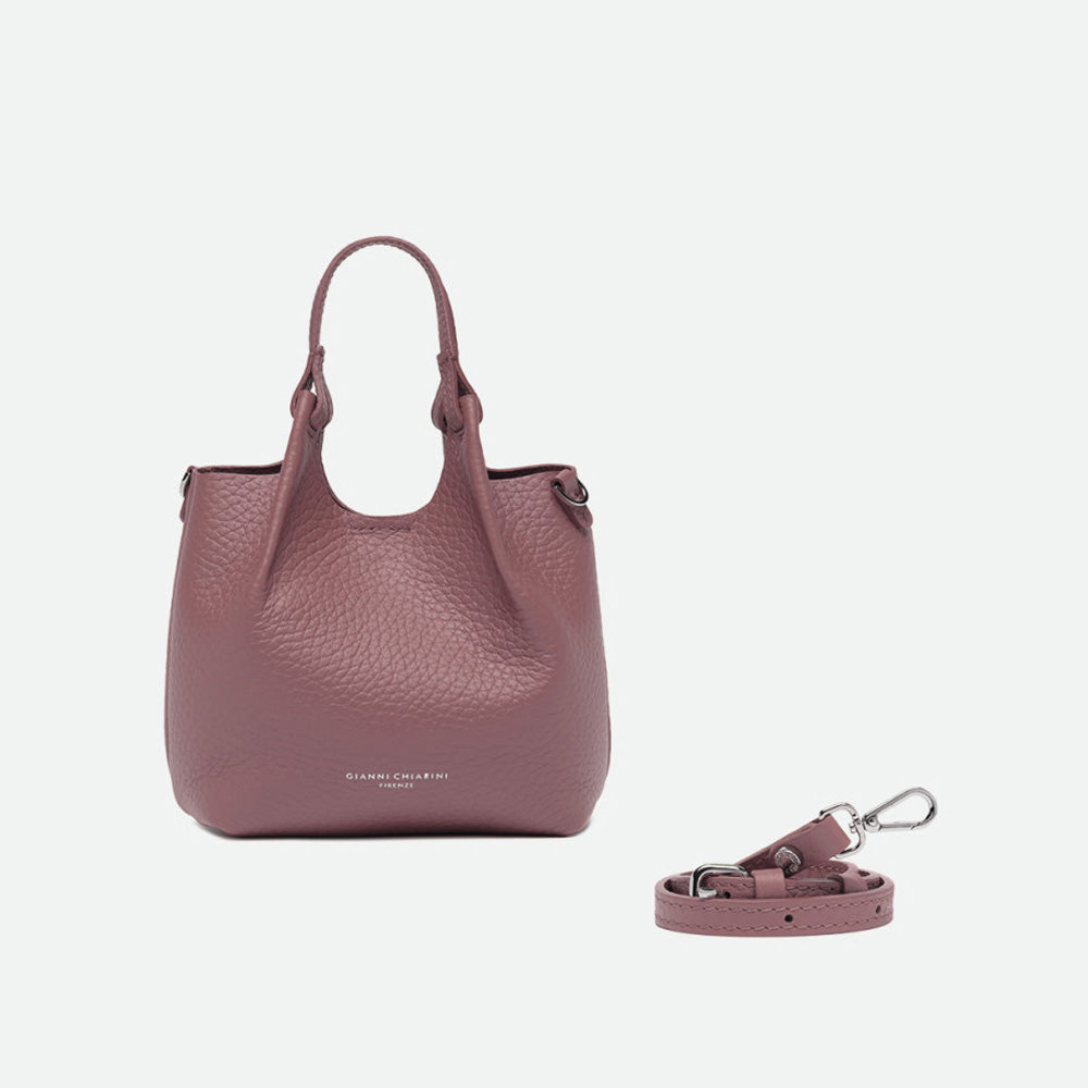Small dusty pink leather tote with its sides opened out, beside a separate shoulder strap