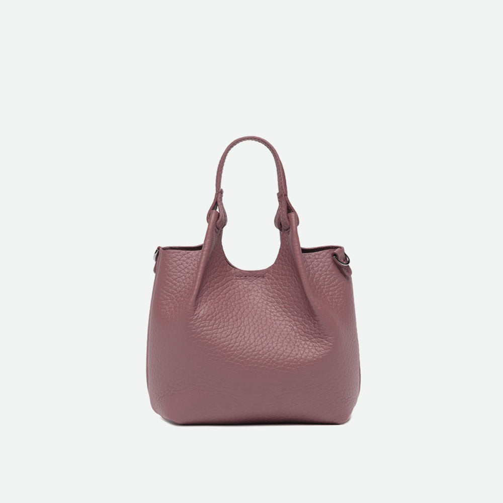 Front of a small dusty pink pebbled leather tote with its sides opened out