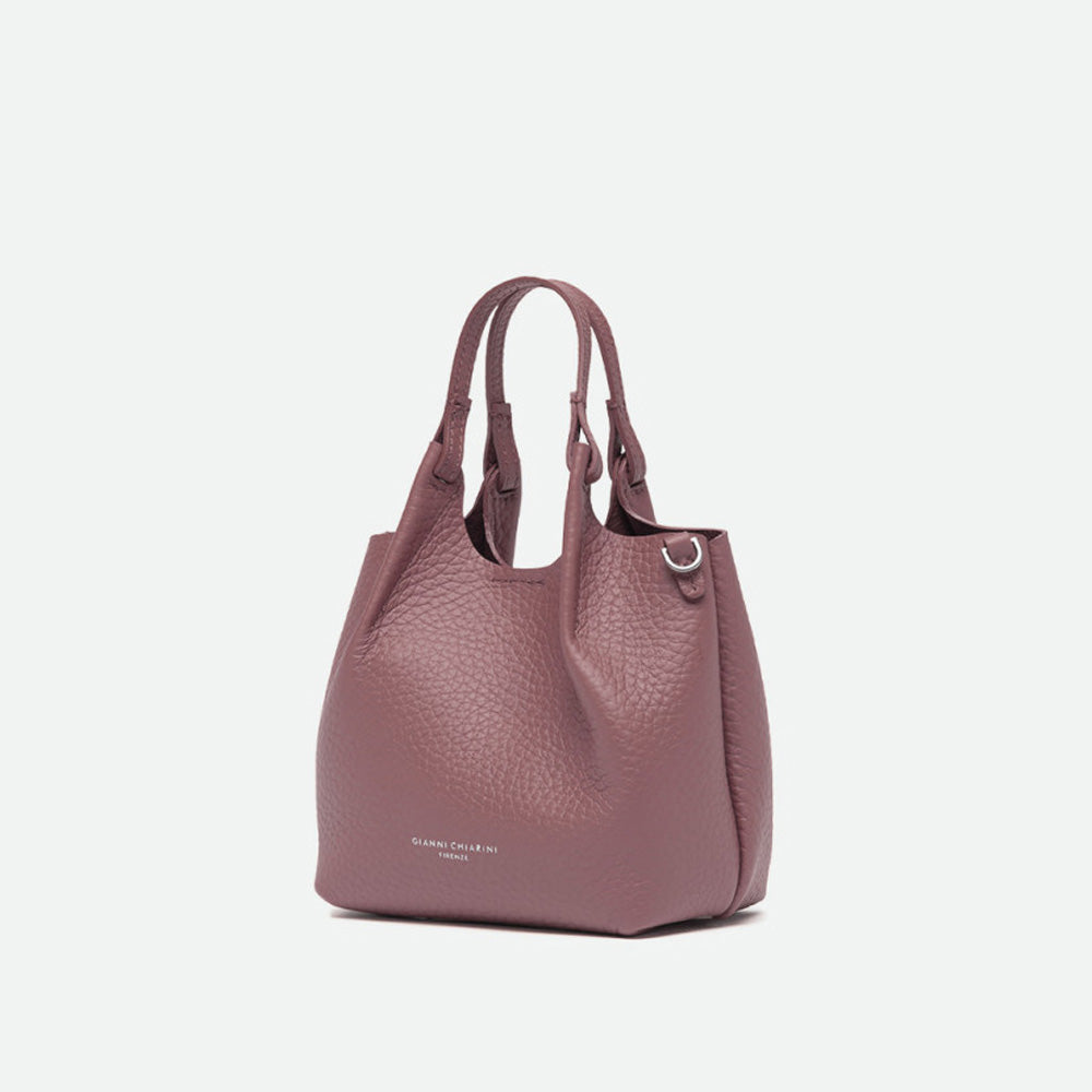Angled view of a small dusty pink pebbled leather tote bag