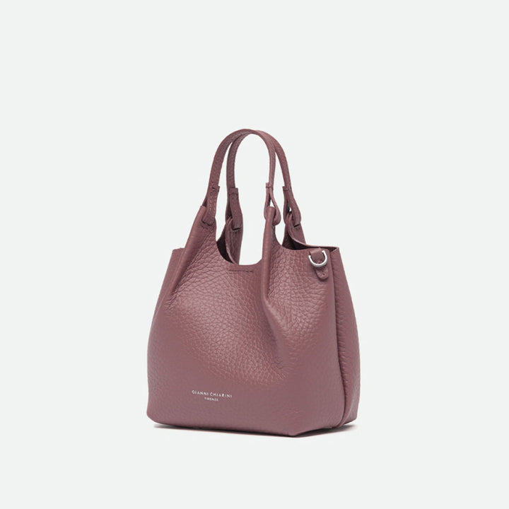 Angled view of a small dusty pink pebbled leather tote bag