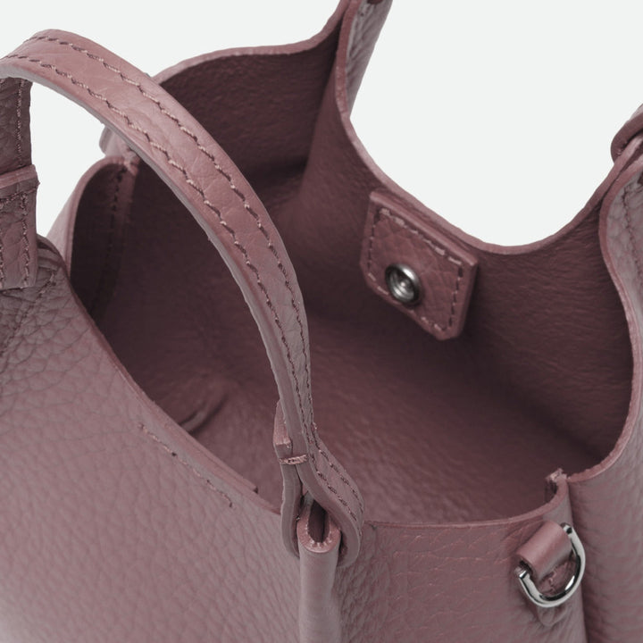 Inside a dusty pink leather bag showing the unlined interior and magnetic clasp