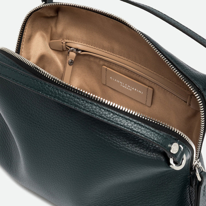 Inside a dark green leather bag showing a tan lining, zip pocket and silver zip