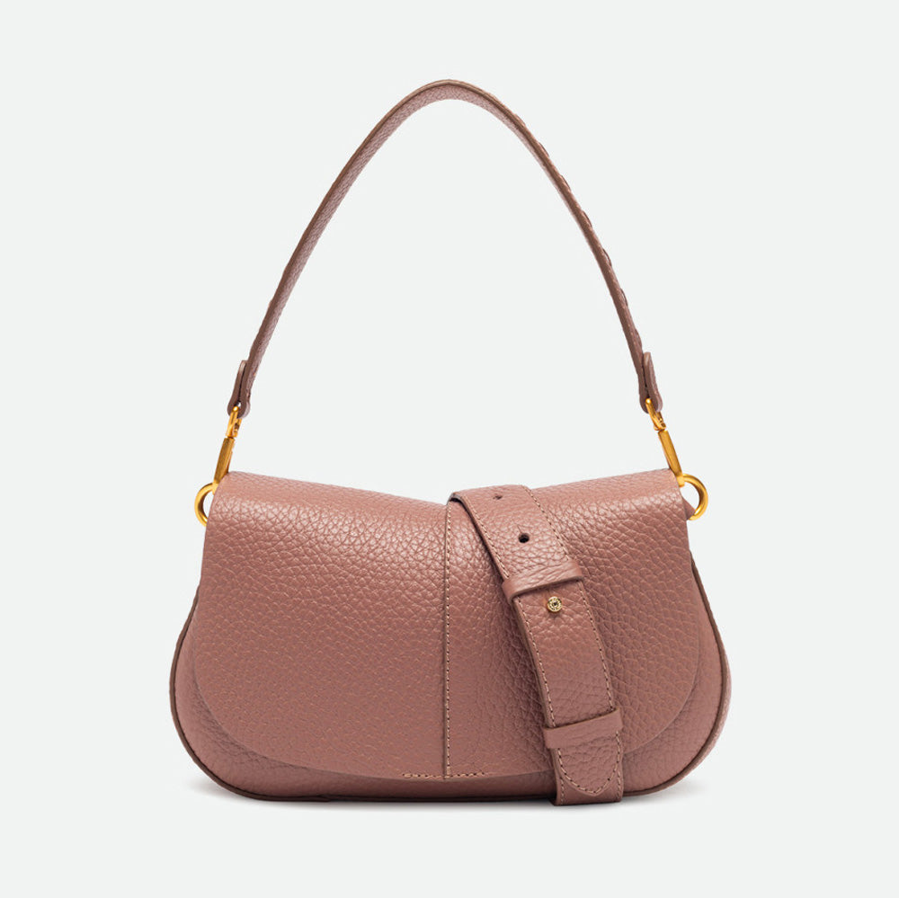 Dusty pink pebbled leather shoulder bag with a buckled flap and gold hardware