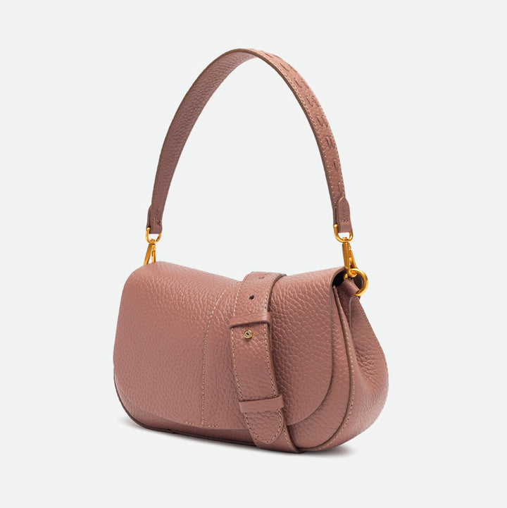Side view of a dusty pink leather shoulder bag with a buckled strap