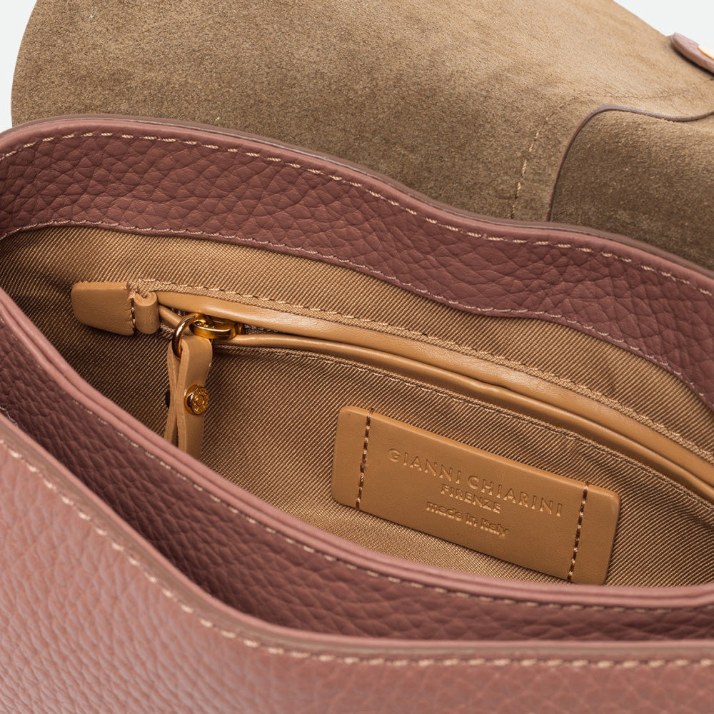 Inside a dusty pink leather bag showing a tan lining and zip pocket
