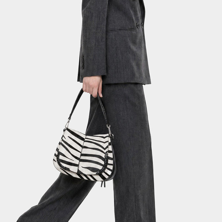 Woman in grey trousers carrying a zebra print shoulder bag