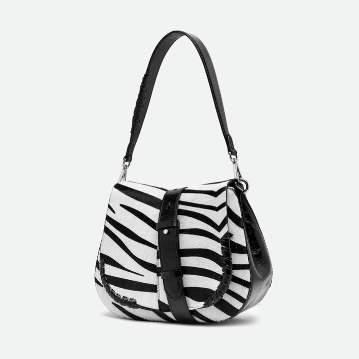 Angled view of a zebra print shoulder bag with a black leather buckled strap