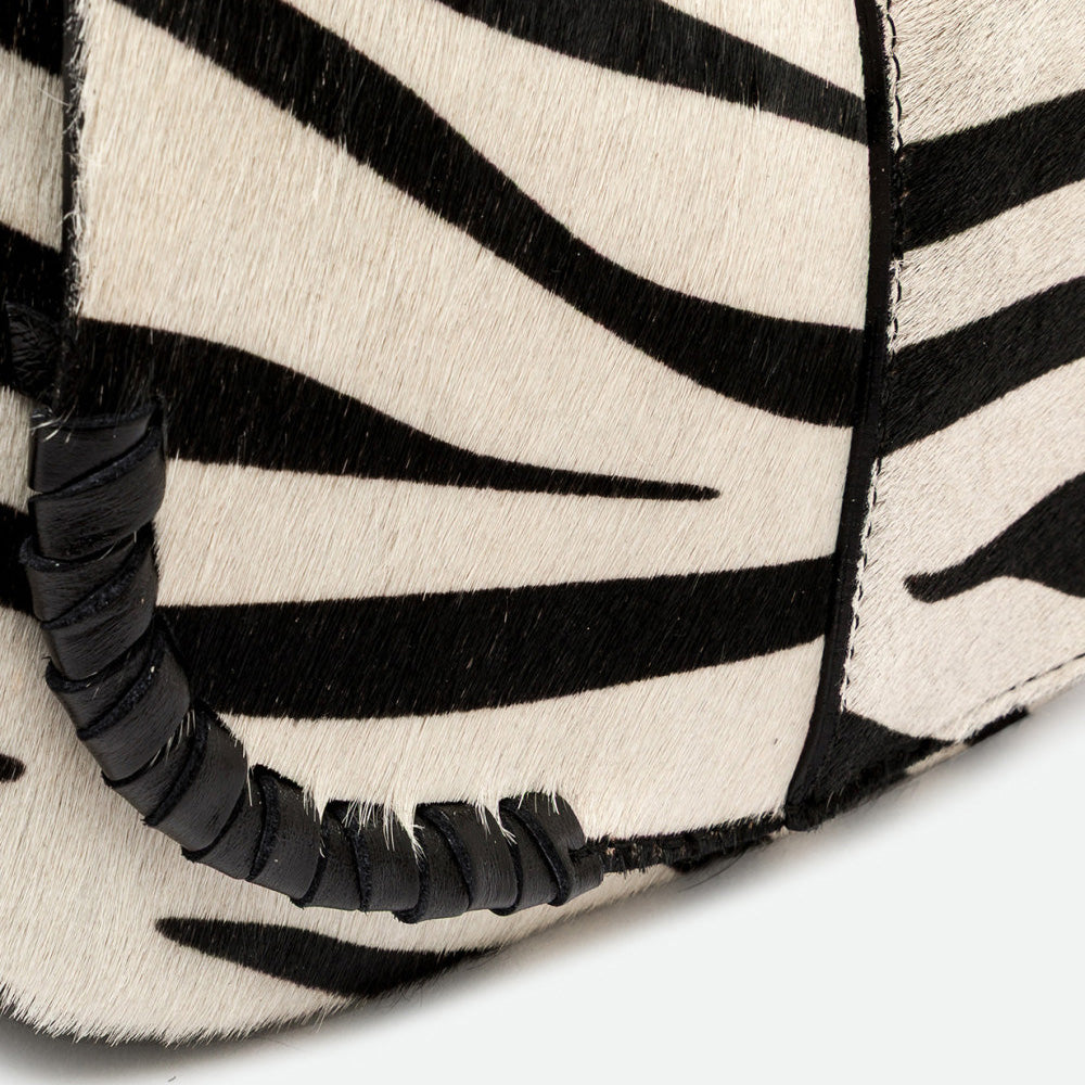 Close-up of black and cream zebra print with a woven black leather trim