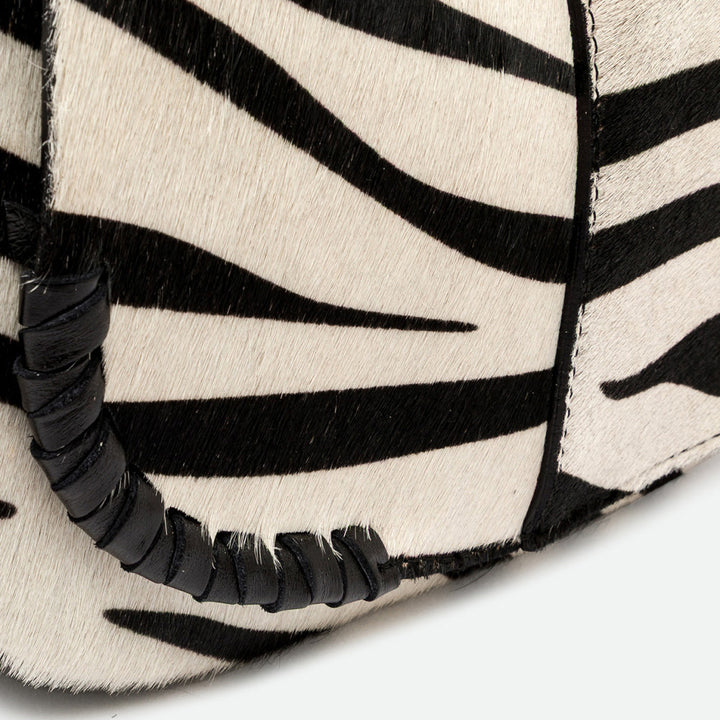 Close-up of black and cream zebra print with a woven black leather trim