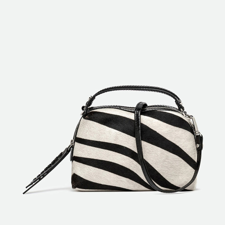 Small black and cream zebra print handbag with black leather handles and crossbody strap
