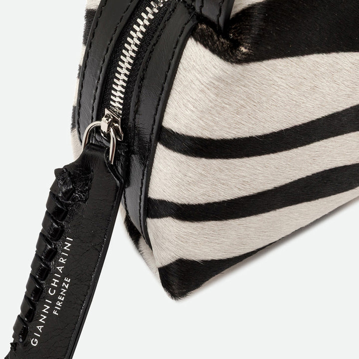 Close-up of a silver zip and black leather pull tag on a zebra print bag