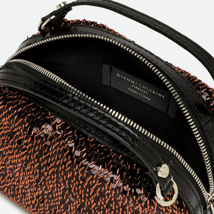 Inside a bronze sequinned bag showing a black lining and silver zip