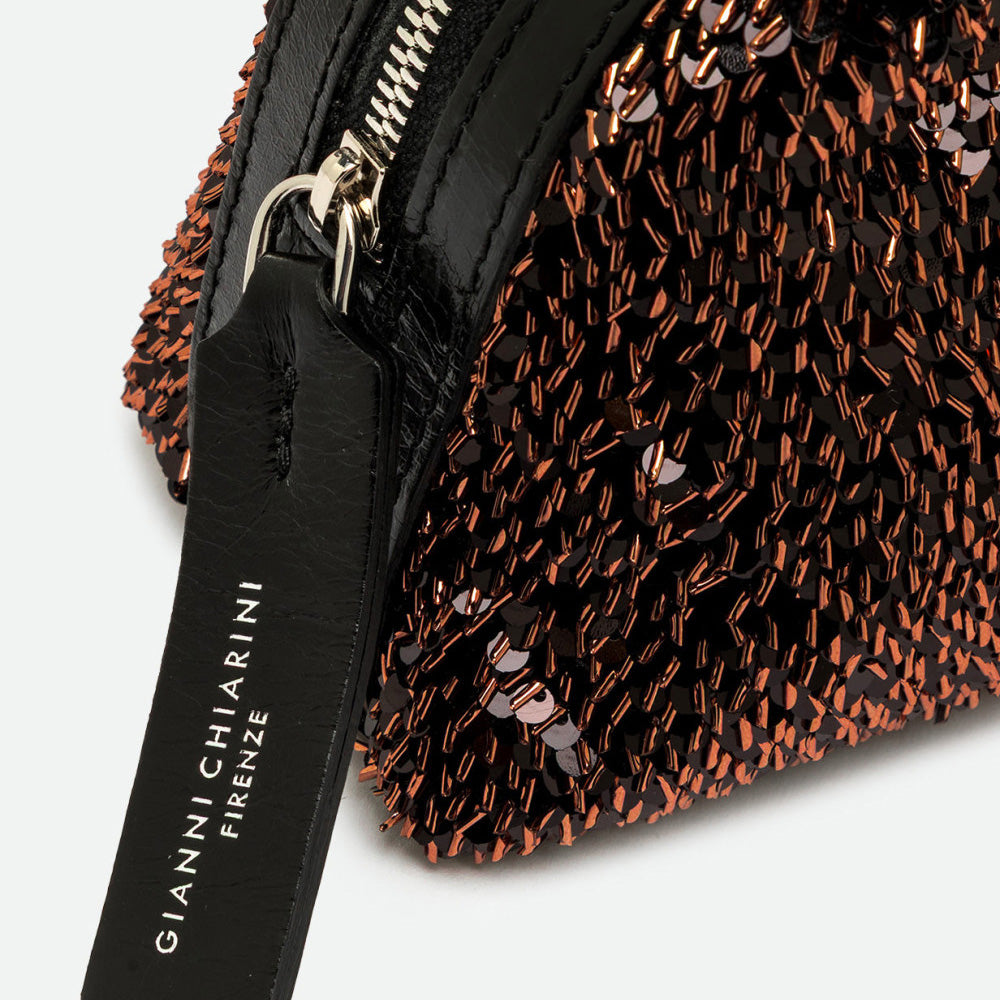 Close-up of bronze sequins and a black leather pull tag