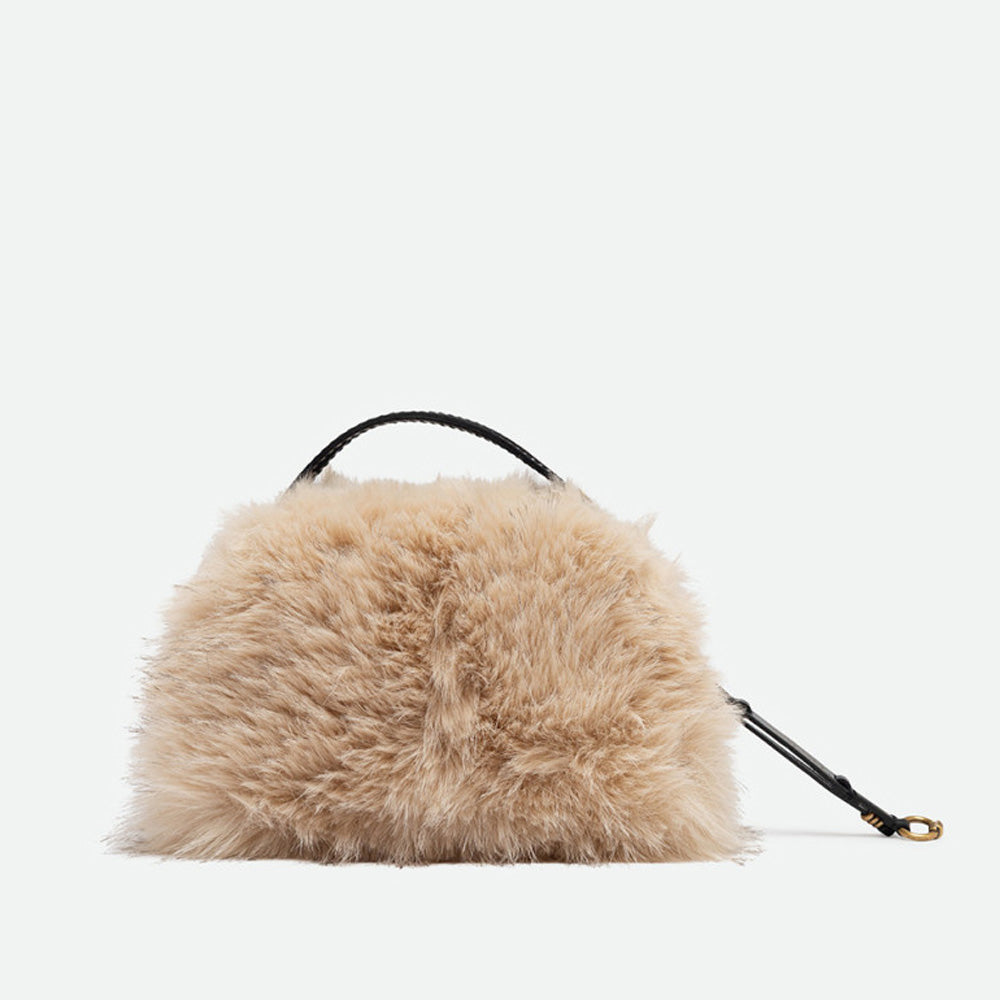 Front of a small cream faux fur handbag with a zip top