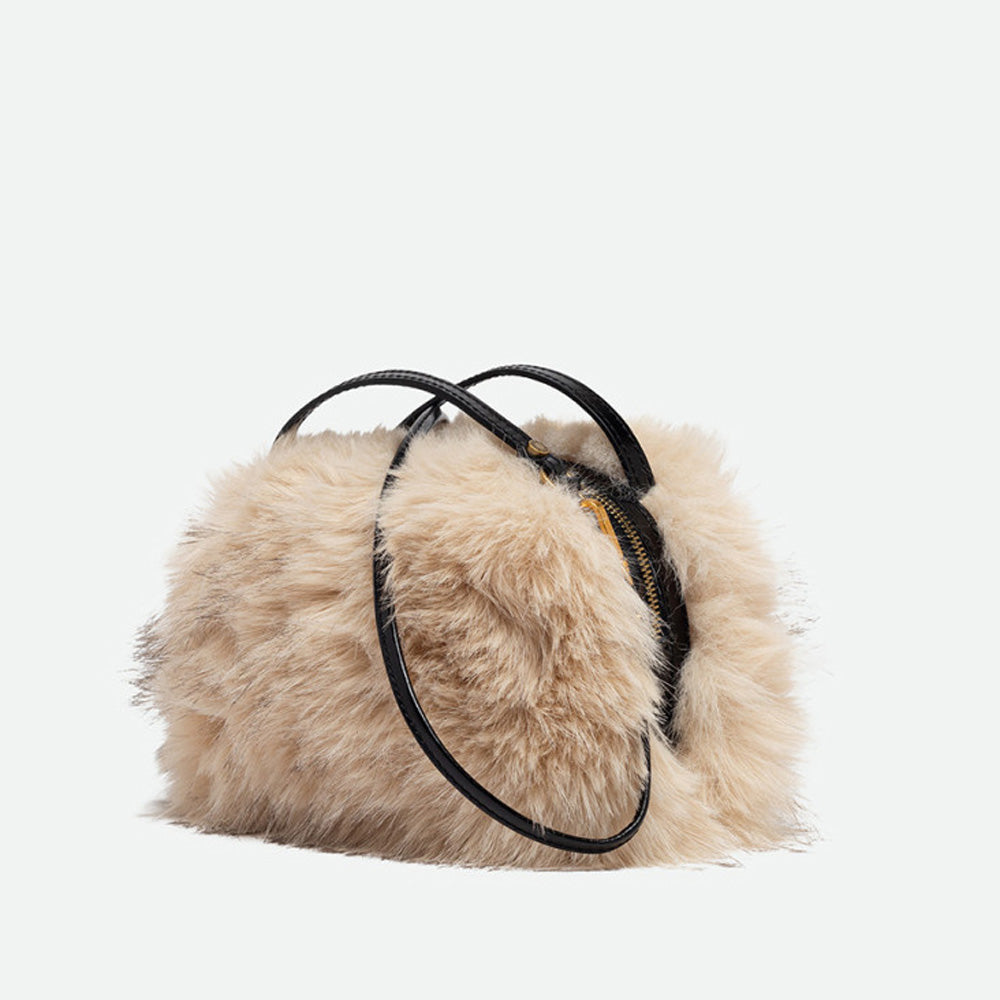 Angled view of a cream faux fur handbag with its crossbody strap attached