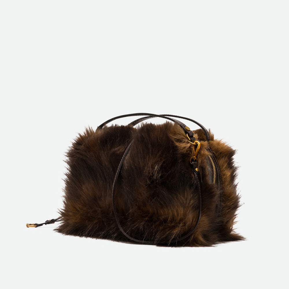 Angled view of a brown faux fur handbag with antique gold hardware
