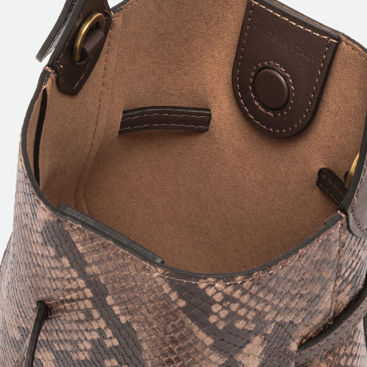 Inside a brown snake print bucket bag showing a tan suede-look interior