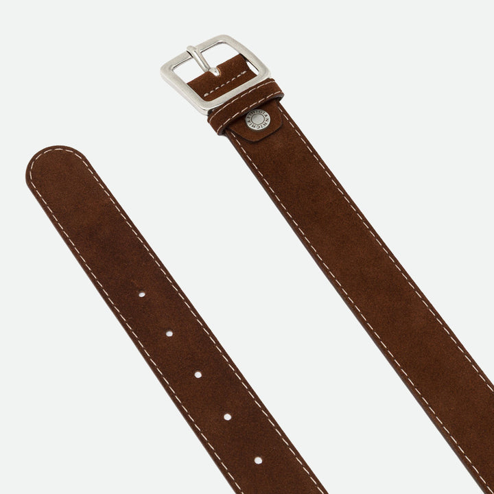 Close-up of a brown suede belt showing the silver buckle, stud and punched holes
