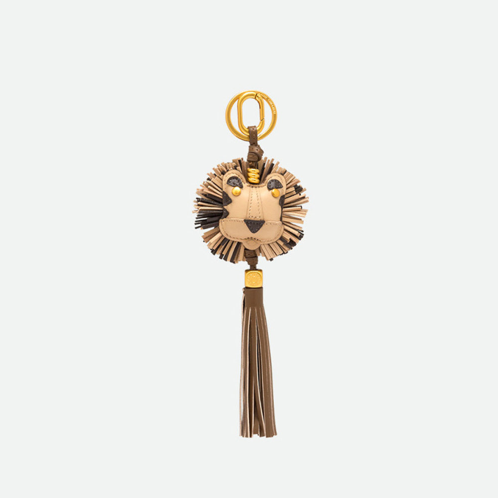 Lion head bag charm with a fringed tan and brown mane and a long tassel