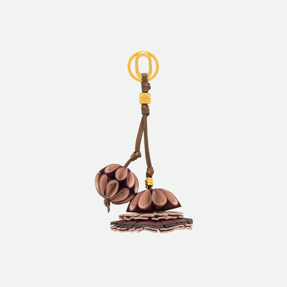 Bag charm with pink and plum layered petal flowers on a brown cord and gold clasp