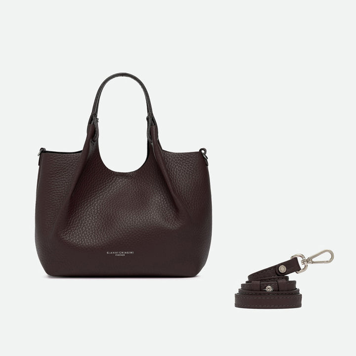 Dark brown leather tote with its sides opened out, beside a separate shoulder strap