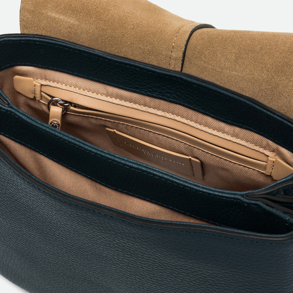 Inside a dark green leather bag showing a tan lining and zip pocket