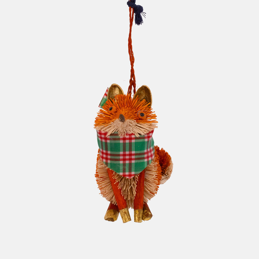 Orange bristle fox ornament sitting upright wearing a red, green and white tartan scarf, with a navy and orange cord